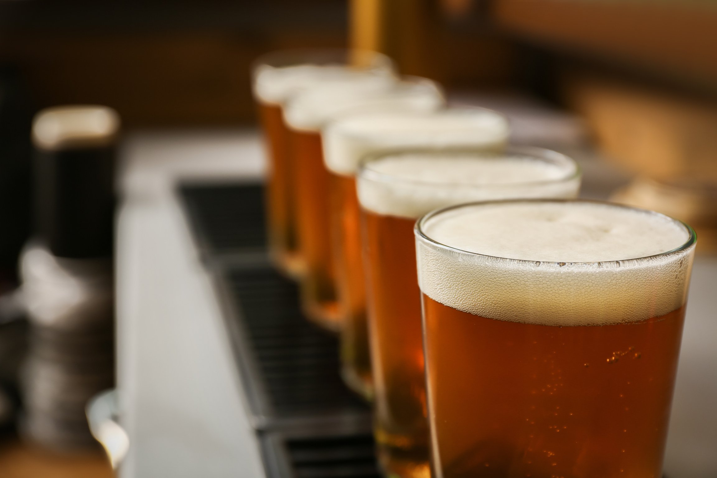 Glasses of Fresh Draft Beer on Bar Counter